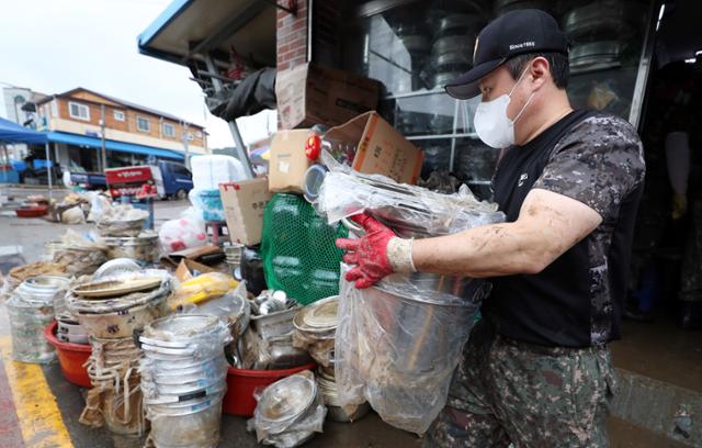 7일 오전 전남 진도군 진도읍 조금시장에서 육군 31보병사단 장병이 장맛비 침수 피해 복구를 돕고 있다. 연합뉴스