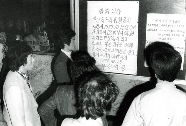 1979년 10월 18일 통금 연장에 따라 열차운행 시간이 바뀌었음을 알리는 공고문이 붙은 부산역 대합실. 역에 나온 시민들이 공고문을 읽고 있다. 한국일보 자료사진