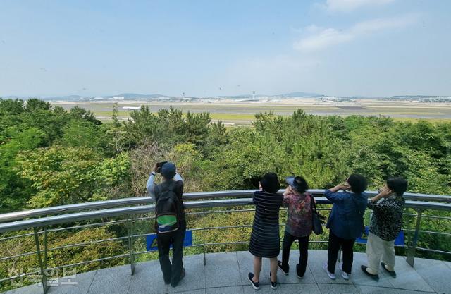 인천국제공항 전망대를 찾은 시민들이 공항 활주로를 바라보다 비행기의 이륙 소음으로 인해 귀를 틀어막고 있다. 서재훈 기자