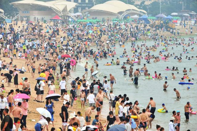 11일(현지시간) 중국 동부 산둥성의 칭다오 해변에서 사람들이 더위를 식히고 있다. AFP 연합뉴스