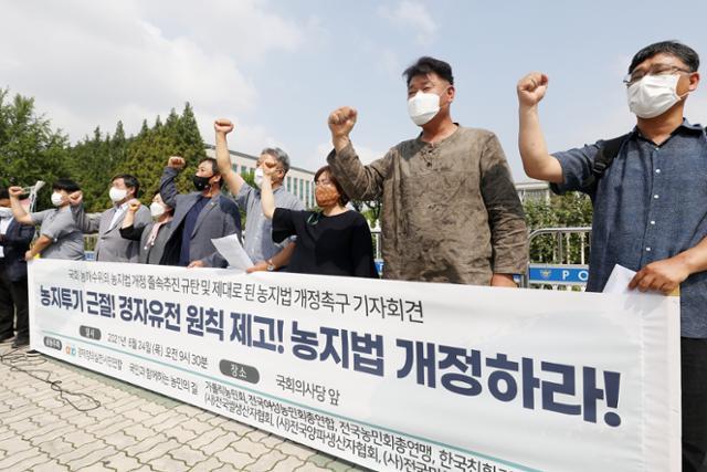 경제정의실천시민연합(경실련)과 국민과 함께하는 농민의길 관계자들이 지난달 24일 오전 서울 영등포구 여의도 국회의사당 앞에서 열린 국회 농해수위의 농지법 개정 졸속 추진 규탄 및 제대로 된 농지법 개정 촉구 기자회견에서 구호를 외치고 있다. 뉴스1