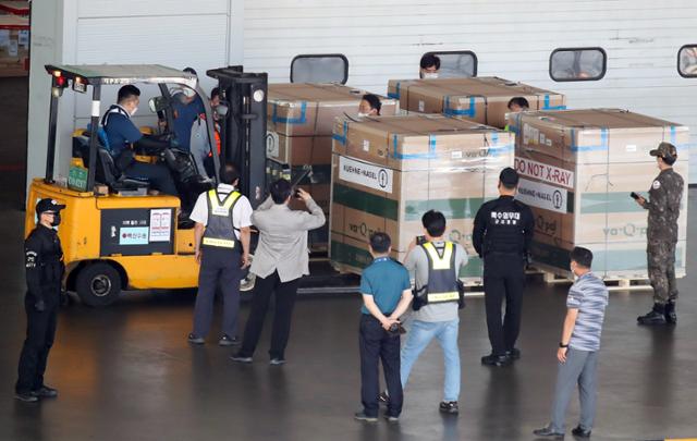 8일 영종도 인천국제공항 화물터미널에서 방역당국 관계자들이 모더나 백신 35만4000회분을 살펴보고 있다. 영종도=연합뉴스