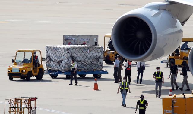 8일 오후 인천국제공항 화물터미널에 도착한 모더나 코로나19 백신 35만4,000회분을 관계자들이 옮기고 있다. 영종도=연합뉴스