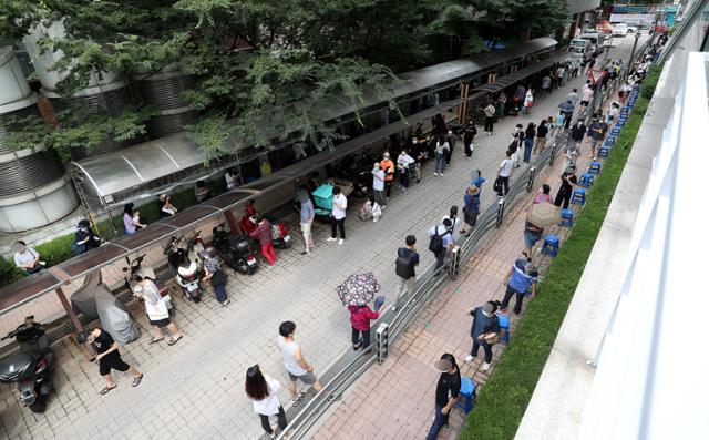 코로나19 확진자가 1,252명을 기록한 19일 오전 서울 관악구보건소에 마련된 선별검사소에서 시민들이 코로나19 검사를 받기 위해 길게 줄 지어 서 있다. 뉴시스