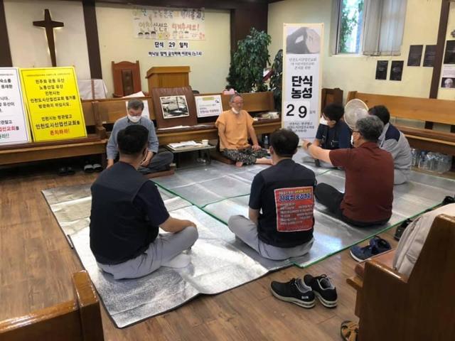 인천 동구 화평동에 있는 인천도시산업선교회(현 미문의일꾼교회) 존치를 요구하며 29일째 단식을 하고 있는 김정택(뒤쪽 왼쪽에서 두 번째) 목사가 20일 교회에서 지지연대 방문을 온 사람들과 대화를 나누고 있다. 인천도시산업선교회 존치를 위한 범시민대책위원회 제공