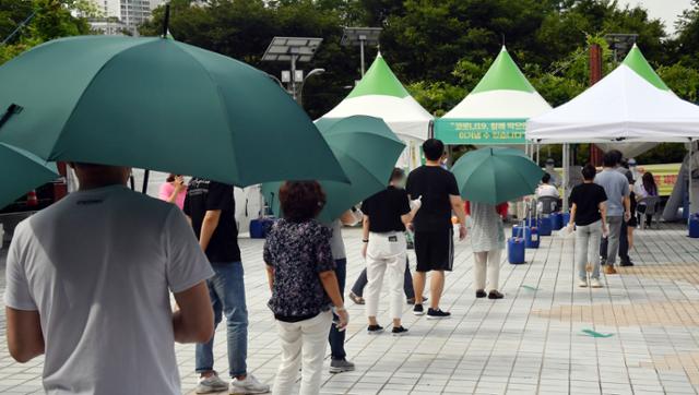 부산지역 코로나19 확진자가 급증세인 21일 오전 연제구 부산시청 등대광장 임시선별검사소를 찾은 시민들이 진단검사를 받기 위해 차례를 기다리고 있다. 뉴시스