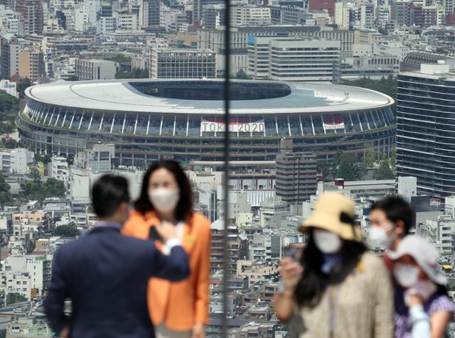 도쿄올림픽 개막식을 이틀 앞둔 21일 일본 도쿄도(東京都)의 한 고층 건물 전망대에서 방문객들이 이번 올림픽의 메인 스타디움인 일본 국립경기장을 배경으로 기념사진을 찍고 있다. 도쿄=연합뉴스