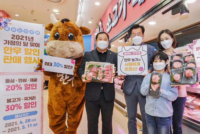 김삼주(왼쪽) 전국한우협회 회장이 지난 5월 가정의 달 맞이 한우할인판매 행사에서 한우선물세트를 들고 소비자들과 함께 사진을 찍고 있다. 전국한우협회 제공