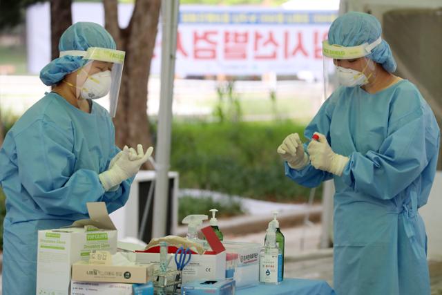 폭염이 이어진 23일 오후 대구 달서구 두류야구장 임시선별검사소에서 의료진이 코로나19 진단검사를 준비하고 있다. 대구=뉴스1