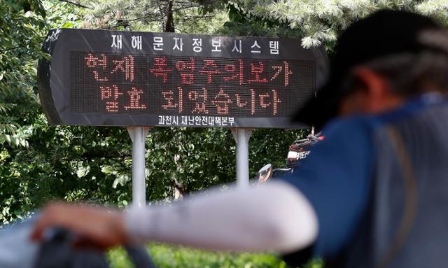 폭염이 이어진 25일 경기 과천 중앙동 계곡 인근에 재해문자정보시스템 전광판에 '폭염주의보 발효' 안내가 나오고 있다. 뉴시스