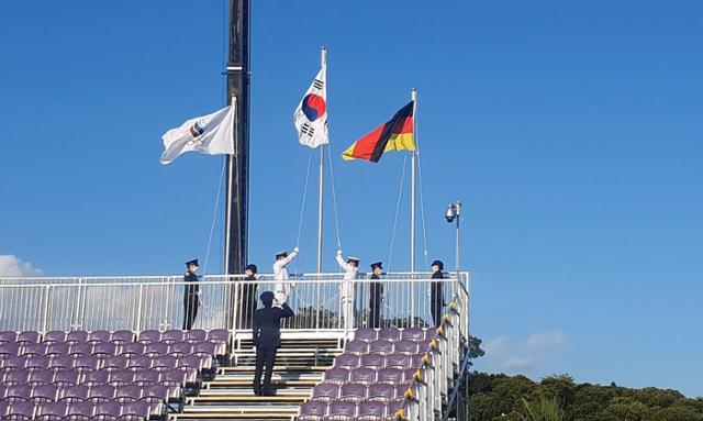 육해공 자위대 대원들이 26일 일본 도쿄 유메노시마 공원 양궁장에서 열린 여자 양궁 단체전 시상식에서 국기를 게양하고 있다. 최동순 기자