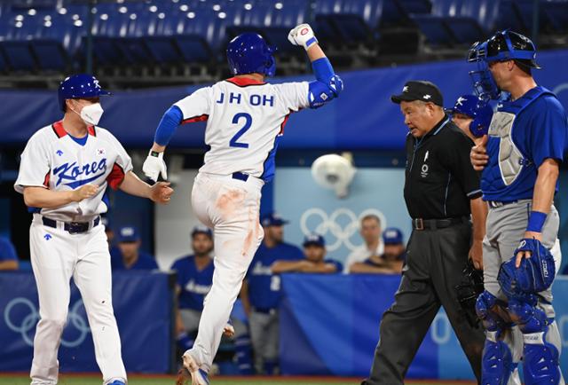 대한민국 야구대표팀 오지환이 29일 일본 요코하마 야구장에서 열린 대한민국과 이스라엘의 조별리그 1차전 4회 말 2사 1루에서 동점 투런포를 친 뒤 홈을 밟은 뒤 동료들과 기뻐하고 있다. 요코하마=올림픽사진공동취재단