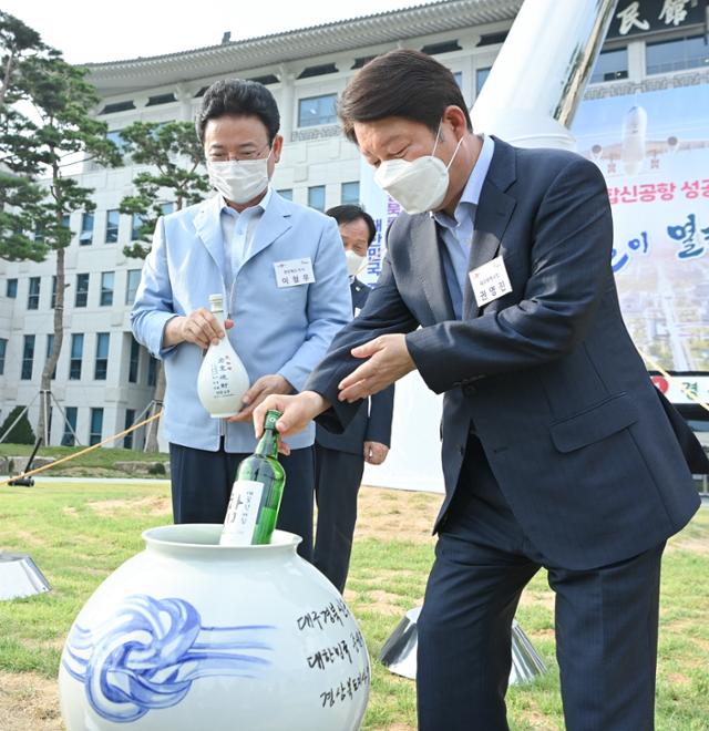 권영진(오른쪽) 대구시장과 이철우 경북도지사가 30일 경북도청 앞마당에서 열린 대구경북통합신공항 조형물 제막식에서 타임캡슐에 소주병 등을 넣고 있다. 경북도 제공