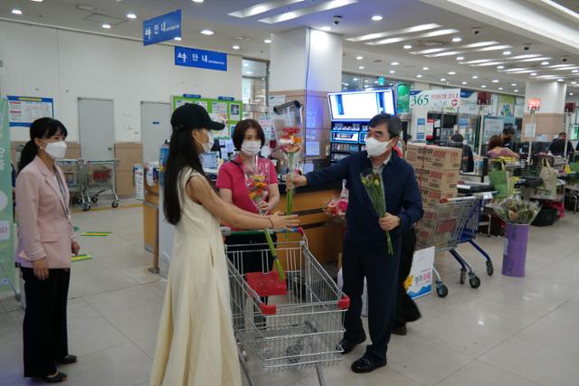 남정순(오른쪽) 영주농협 조합장이 파머스마켓 방문 고객에게 꽃을 나눠주고 있다. 영주농협 제공