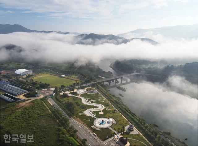 용담댐 아래 용담가족공원 주변 강과 산자락이 운무에 휩싸여 있다. 공원 바닥에 용이 꿈틀대는 형상으로 산책로를 조성해 놓았다.