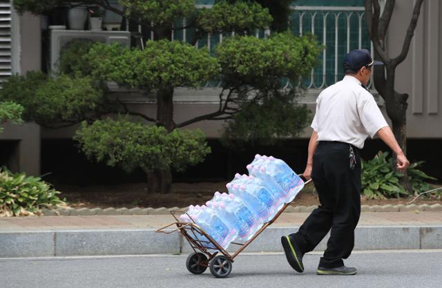 지난 2019년 6월 서울 내 한 아파트 단지에서 경비원이 물을 수레로 운반하고 있다. 기사 본문에 언급된 아파트와는 무관함. 연합뉴스