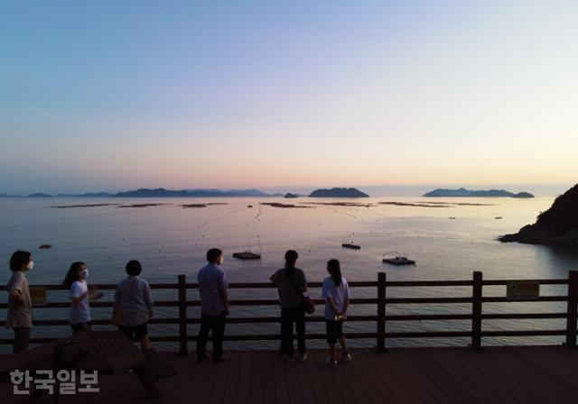 완도 서부 해안도로 미소공원의 노을. 다도해 섬들을 배경으로 바다 위에 엷은 노을이 번지고 있다.