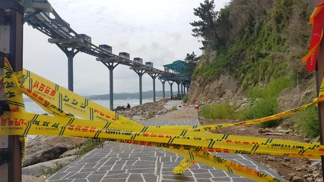 경북 울진군이 죽변항 바닷가에 설치한 산책길이 높은 파도로 통제된 가운데 12일 오후 기상 악화로 개장 6일 만에 운행을 멈춘 해안스카이레일 전동차가 레일 위로 줄지어 서 있다. 김정혜 기자