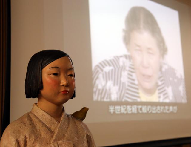 지난달 24일 일본 교토부(京都府) 교토시의 한 시설에 전시된 '평화의 소녀상' 뒤로 자신이 일본군 위안부 피해자라는 사실을 처음으로 공개 증언한 고(故) 김학순(金學順·1924∼1997)씨의 영상이 상영되고 있다. 교토=연합뉴스