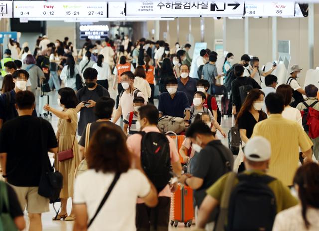 광복절 연휴를 하루 앞둔 13일 오후 김포공항 국내선 청사에서 시민들이 항공권 발권을 위해 이동하고 있다. 연합뉴스