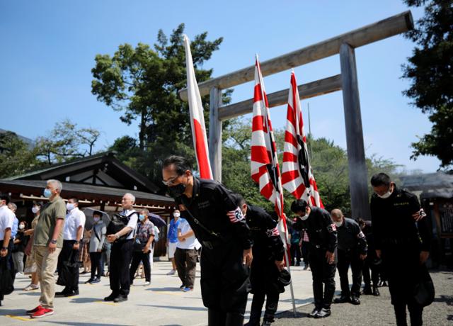 일본의 제2차 세계대전 패전 75주년인 지난해 8월 15일 도쿄에서 일장기와 전범기를 든 우익단체 회원들이 야스쿠니 신사에 절을 하고 있다. 도쿄=로이터 연합뉴스