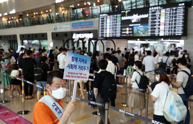 광복절 연휴를 하루 앞둔 13일 오후 김포공항 국내선 청사를 이용하는 여행객들이 출국 전 보안검색을 위해 줄 서 있다. 연합뉴스