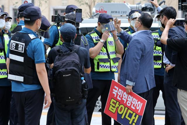 국민혁명당 문재인 정권 탄핵을 위한 8.15 국민대회 추진위원회 구성원들이 지난 2일 오전 서울 세종대로 동화면세점 앞에서 기자회견 중 경찰이 해산 요구를 하자 반발하고 있다. 이들은 문재인 정권 탄핵을 위한 8.15 국민대회를 개최할 것이라고 말했다. 뉴스1