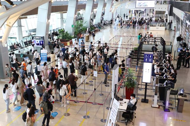 광복절 연휴를 하루 앞둔 지난 13일 오후 김포공항 국내선 청사를 이용하는 여행객들이 출국 전 보안검색을 위해 줄 서 있다. 연합뉴스