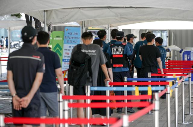 광복절 연휴 기간 동안 집회 관리 임무를 수행한 경찰들이 16일 중구 서울광장에 설치된 코로나19 임시선별검사소에서 검사를 받기 위해 줄 서 있다. 뉴시스