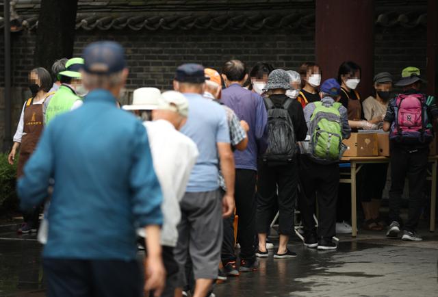 서울 탑골공원에서 노인들이 무료급식을 위해 줄을 서고 있다. 연합뉴스