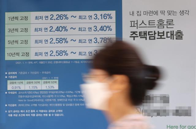 18일 서울 시내 한 은행 앞에 걸린 주택담보대출 광고 앞을 한 시민이 지나가고 있다. 연합뉴스