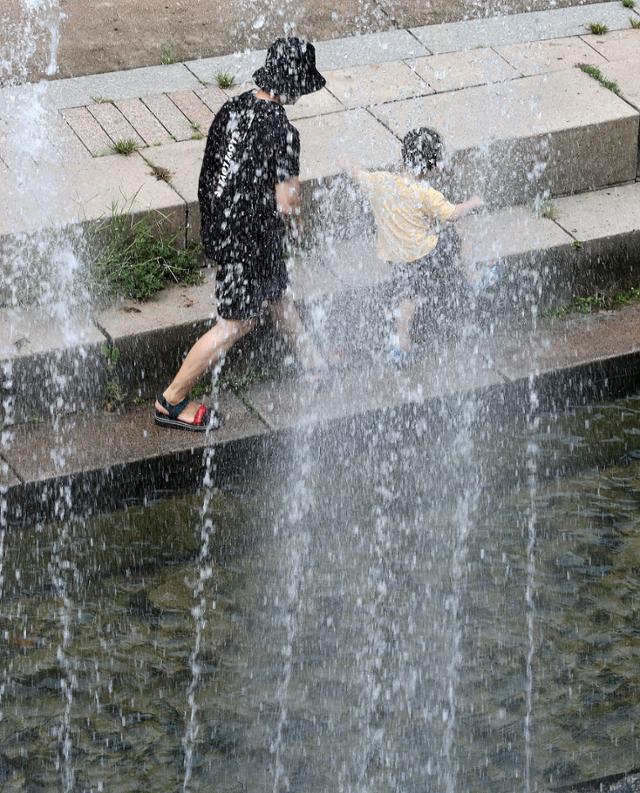 가을장마로 인해 내리던 비가 그친 25일 오후 서울 중구 청계천 분수 앞에서 한 어린이가 뛰어놀고 있다. 뉴시스