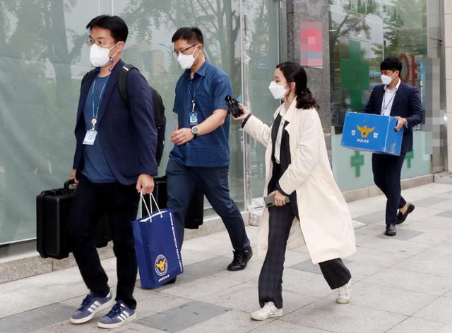 지난 5월 27일 오전 인천경찰청 광역수사대 경찰관들이 '대리수술 의혹'을 받는 인천 모 척추 전문병원 건물에서 압수한 자료 등을 들고 나오고 있다. 연합뉴스