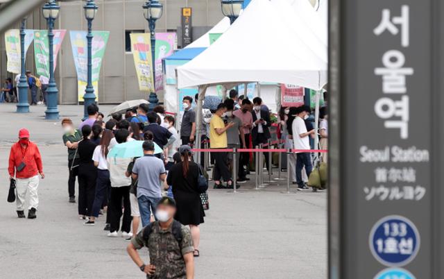 코로나19 일일 신규 확진자 수가 2,155명으로 집계된 25일 오후 서울 중구 서울역에 마련된 임시선별검사소에서 시민들이 검사를 기다리고 있다. 뉴시스