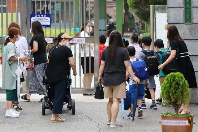 23일 서울의 한 초등학교에서 개학을 맞은 어린이들이 보호자와 함께 등교하고 있다. 뉴스1