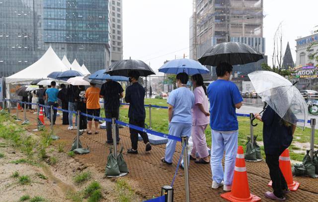 가을 장마 비가 내린 31일 오후 서울 용산구 용산역 앞 광장에서 시민들이 우산을 쓰고 코로나 검사를 받기위 위해 대기하고 있다. 배우한 기자