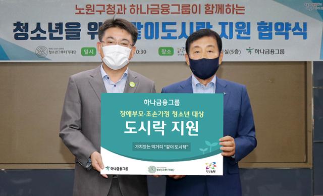 김정태(오른쪽) 하나금융그룹 회장 겸 청소년그루터기재단 이사장과 오승록 서울 노원구청장이 13일 오전 노원구청에서 청소년을 위한 '같이(가치) 도시락' 지원 사업 협약을 체결한 뒤 기념촬영을 하고 있다. 하나금융그룹 제공.