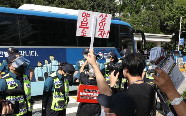 15일 '정인이 사건'(생후 16개월 입양아 학대 사망 사건) 2심 첫 재판이 열리는 서울 서초구 서울고등법원 앞에서 시민들이 양부모가 탄 호송차량을 향해 구호를 외치고 있다. 양부모는 정인이의 사망에 고의성이 없었다면서 살인죄를 부인 중이며, 1심은 양모와 양부에게 각각 무기징역과 5년형을 선고한 바 있다. 뉴스1