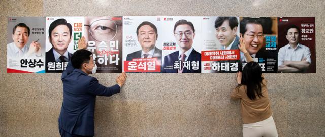 국민의힘 당직자가 24일 오후 서울 여의도 국회 본관 복도에 국민의힘 제20대 대통령선거 경선 예비 후보 포스터를 부착하고 있다. 국회사진기자단