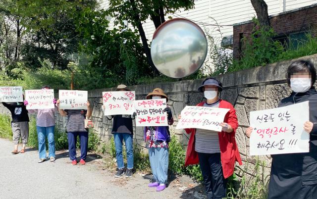 충남 천안시 동남구 수신면 장산5리 주민들이 지난 3일 마을 인근 공장 앞에서 '암과 갑상선 질환 등 집단 발병'을 호소하며 집회를 열고 있다. 주민들은 이날 환경부 관계자들의 현장 방문에 맞춰 '정부의 신뢰도 있는 역학조사'를 촉구했다. 뉴시스