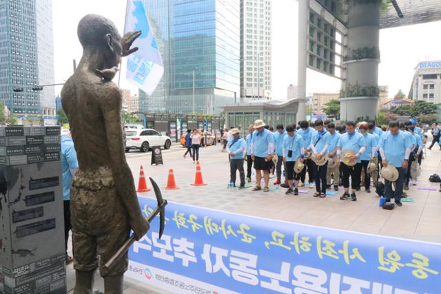 2019년 8월 14일 서울 용산구 용산역 광장 앞에 설치된 강제징용 노동자상 앞에서 노동계 인사들이 묵념하고 있다. 한국일보 자료사진