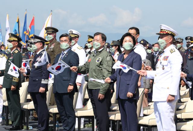 문재인 대통령과 김정숙 여사가 1일 경북 포항 영일만 해상 마라도함에서 열린 제73주년 국군의 날 기념식에서 참석자들과 군가에 맞춰 태극기를 흔들고 있다. 포항=왕태석 선임기자