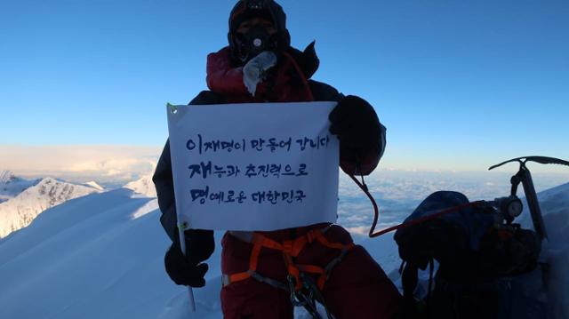 충북 히말라야 원정대 조철희 등반대장이 1일 히말라야 제7위 봉인 네팔 다울라기리 정상에서 '이재명 삼행시' 깃발을 들어보이고 있다. 이재명 캠프 제공