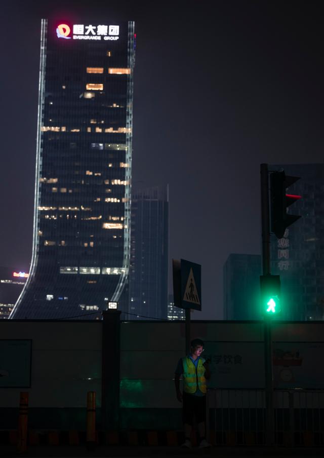 지난달 30일 중국 대형 민간 부동산 개발업체 헝다그룹의 광둥성 선전 본사 앞 도로에 한 남자가 서 있다. 선전=EPA 연합뉴스