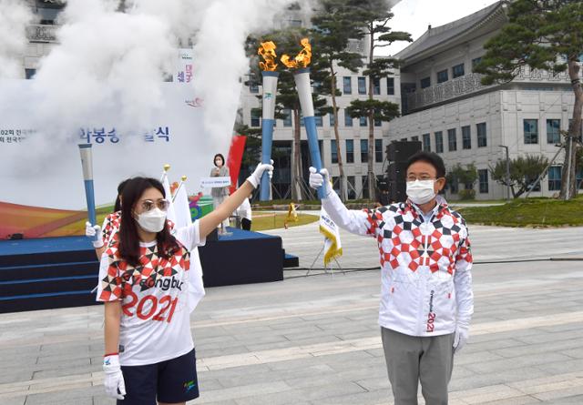 이철우(오른쪽) 경북도지사와 성화봉송 첫 주자가 4일 오전 경북도청 광장에서 성화를 높이 들어 보이고 있다. 경북도 제공