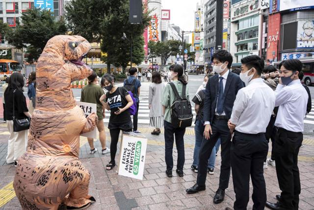 국제동물보호단체 페타(PETA.동물의 윤리적 처우를 지지하는 사람들) 회원들이 6일 일본 도쿄 거리에서 공룡 모습의 복장을 한 채 시민들에게 채식주의자(비건)가 될 것을 촉구하고 있다.도쿄 AFP=연합뉴스