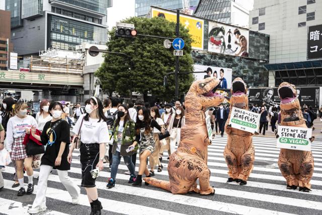 국제동물보호단체 페타(PETA.동물의 윤리적 처우를 지지하는 사람들) 회원들이 6일 일본 도쿄 거리에서 공룡 모습의 복장을 한 채 시민들에게 채식주의자(비건)가 될 것을 촉구하고 있다.도쿄 AFP=연합뉴스