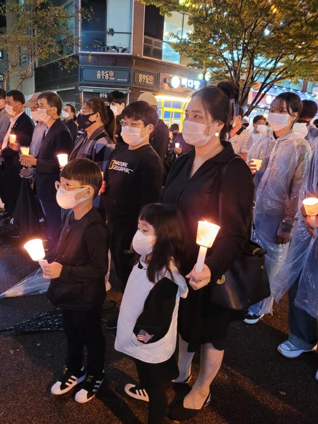 11일 오후 전남 여수 웅동에서 열린 추모문화제에 한 학부모가 자녀들과 함께 참석, 현장실습 중에 사망한 고 홍정운군을 추모하고 있다. 여수=박경우 기자