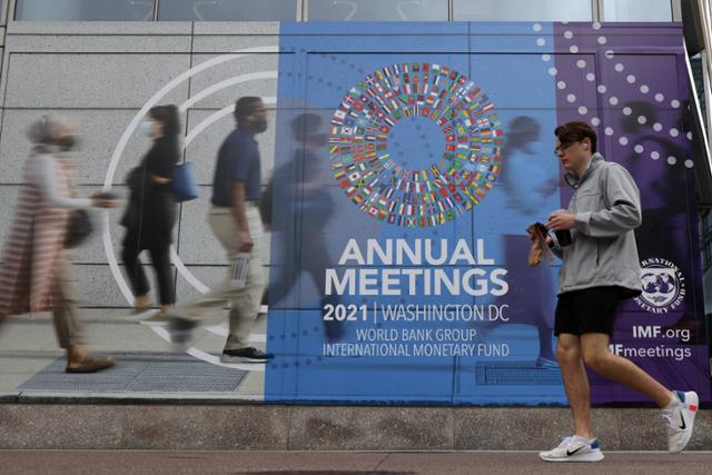 11일 미국 워싱턴에서 한 남성이 세계은행과 국제통화기금(IMF)의 연례회의를 알리는 현수막 앞을 지나가고 있다. 이번 회의는 17일까지 이어진다. 워싱턴=AFP 연합뉴스