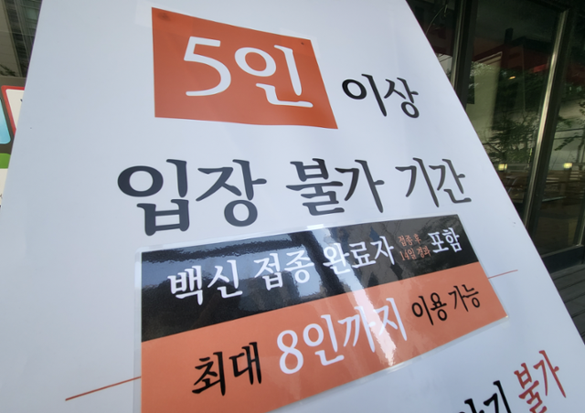 수도권에서 백신 접종자 포함 최대 8인 모임이 가능해진 18일 서울 강남구의 한 고깃집 입구에 완화된 식사 인원 안내문이 적혀 있다. 나광현 견습기자